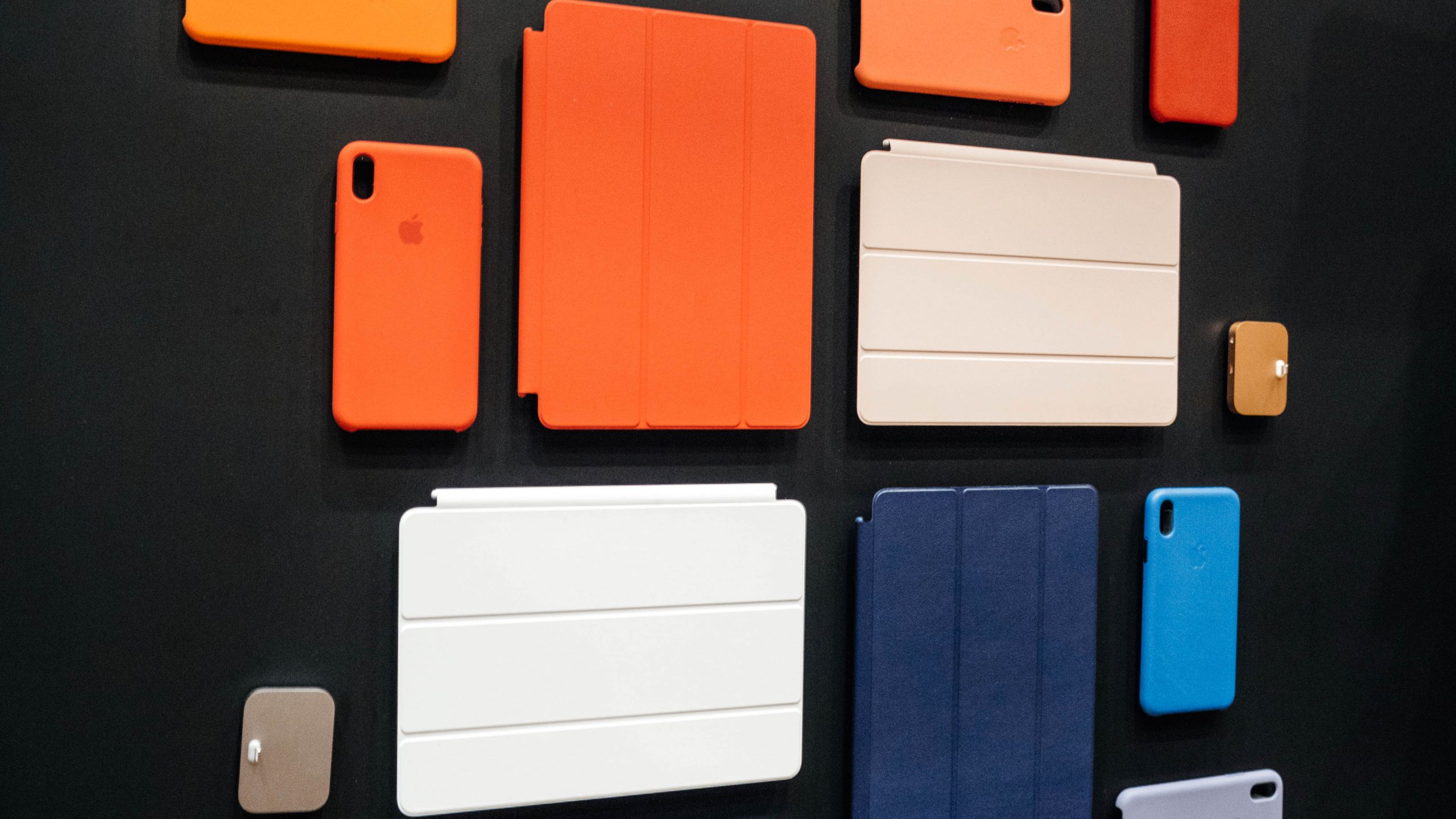 ipad pro cases in orange white and blue on a dark grey background